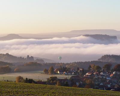 Hohnstein-1  Blick Hohburkersdorf über Rathewalde am Morgen bei 1 Grad, links vor dem Nebel die Lokomotive (Felsen)